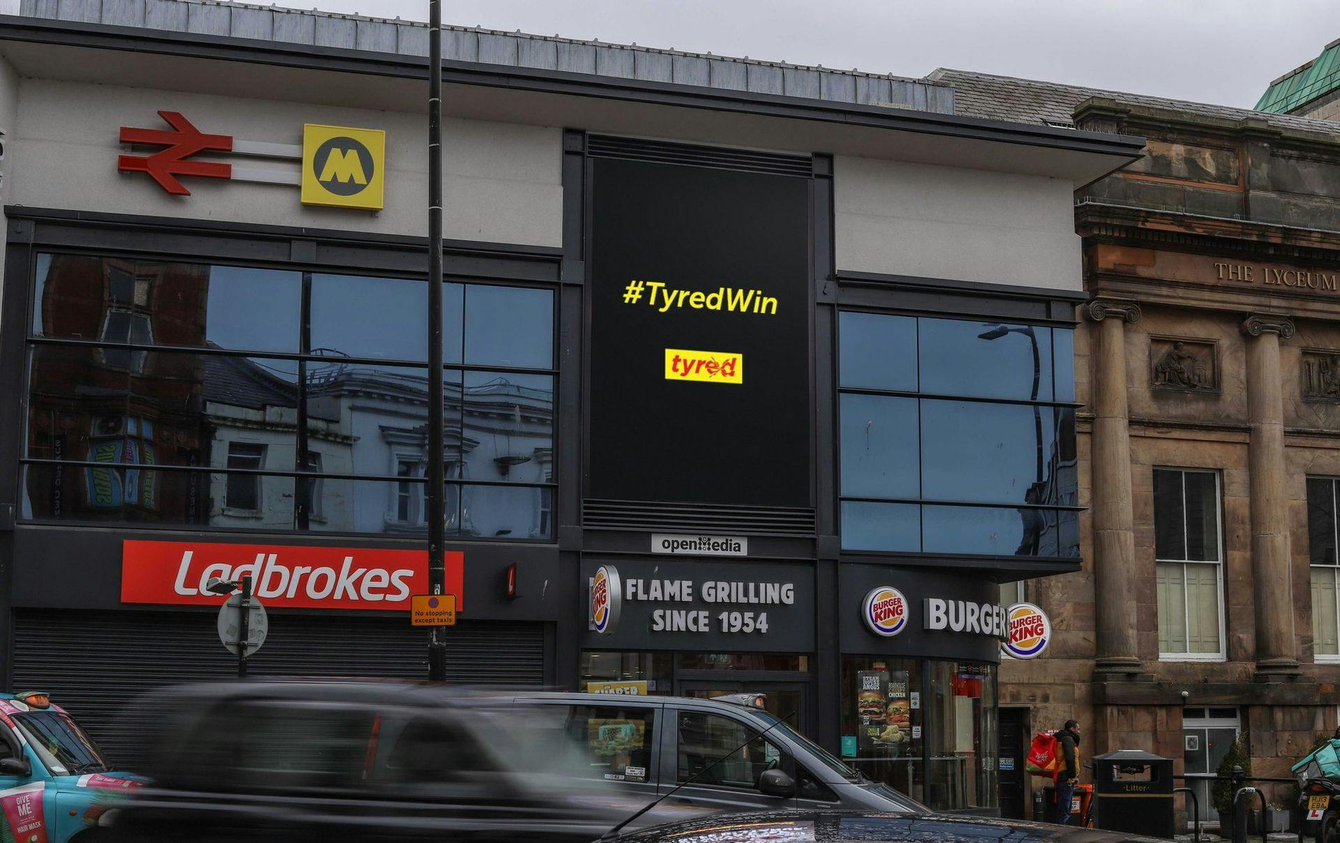 Tyred shown on a screen in a ctiy